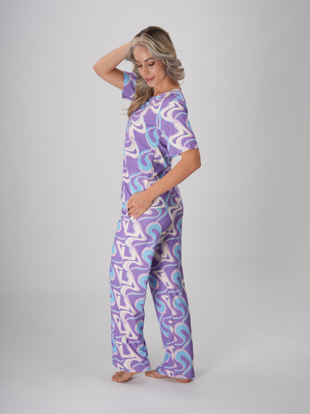 A woman in a lavender twirls pajama set with a swirl pattern in shades of lavender, ivory, and sky blue - Lavender Twirls PJ Set