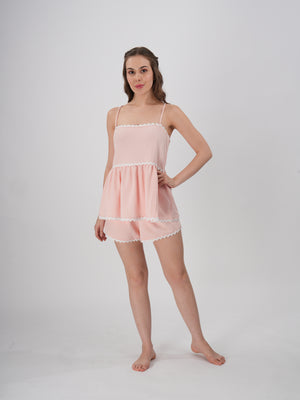 A woman wearing a blush pink loungewear set with a flowy Cami top and matching shorts - Blush Pink Wave Short Set