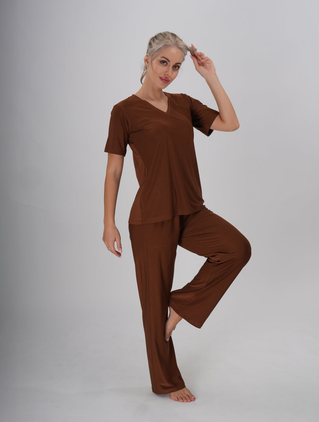 A Woman wearing a brown V-neck, short sleeve T-shirt and mid-rise pants with an elastic waistband - Coffee Crush PJ Set.