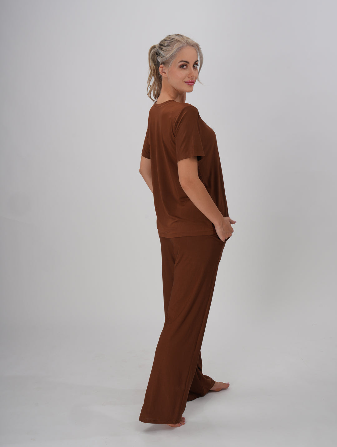 A Woman wearing a brown V-neck, short sleeve T-shirt and mid-rise pants with an elastic waistband - Coffee Crush PJ Set.