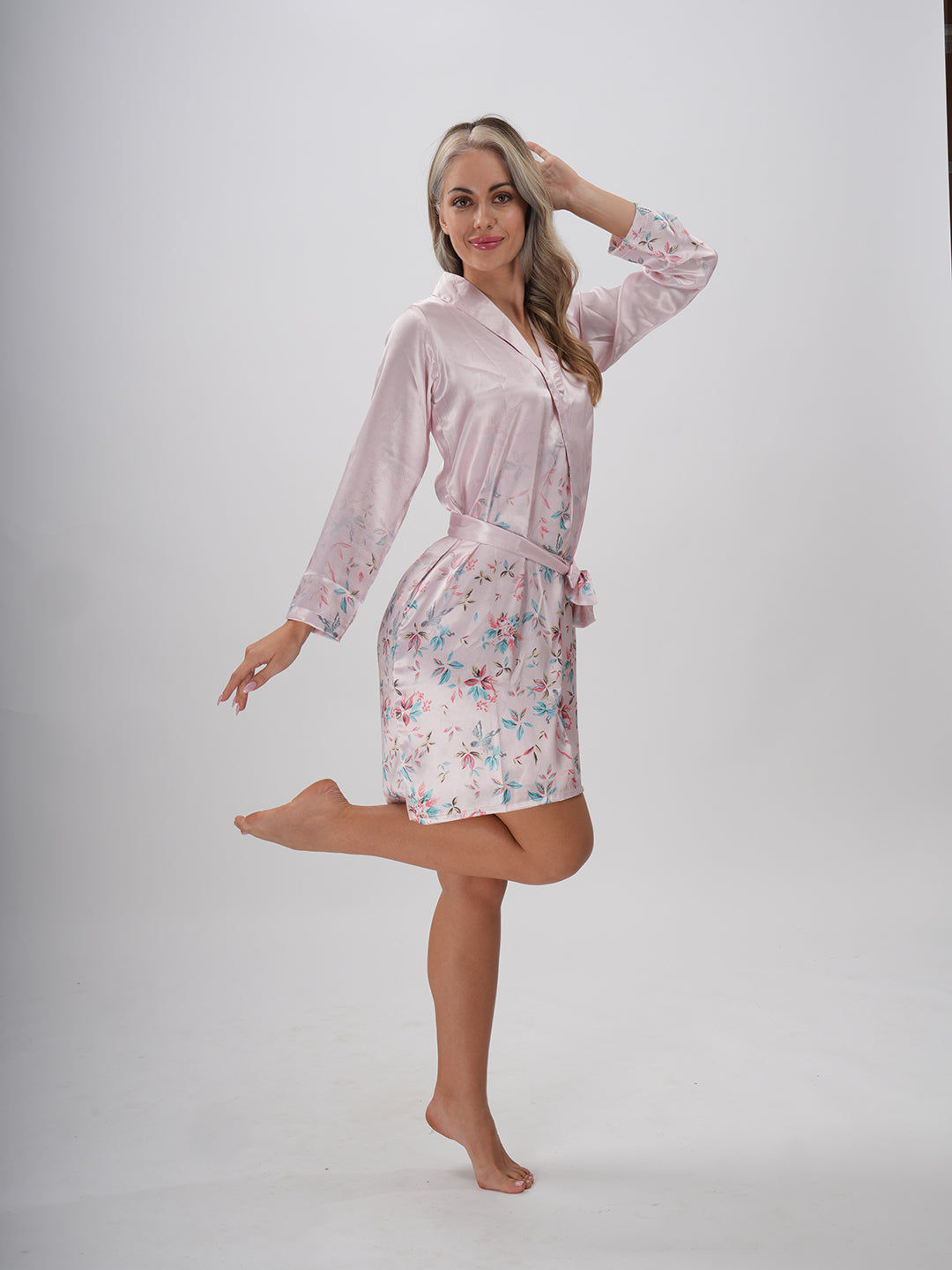 A woman wearing a pink floral robe with a round neckline and a sash belt - Mystical Bloom Robe