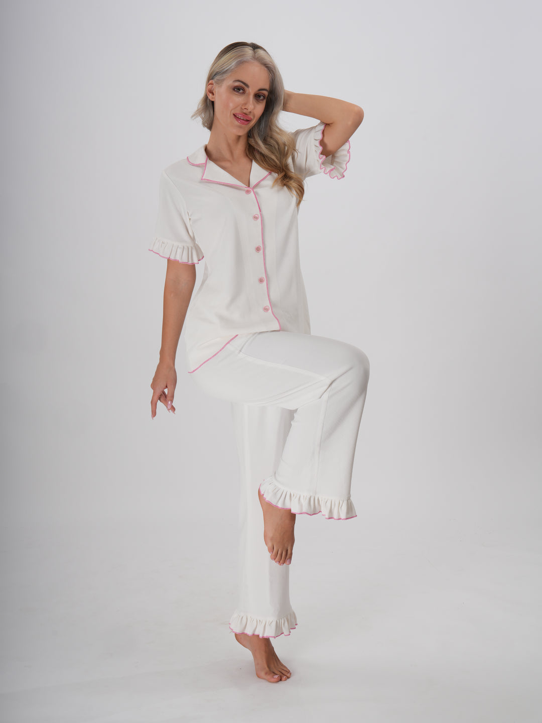 Woman wearing a white pajama set with ruffle trim, classic collar, and button-down top – Sweet Dreams PJ Set
